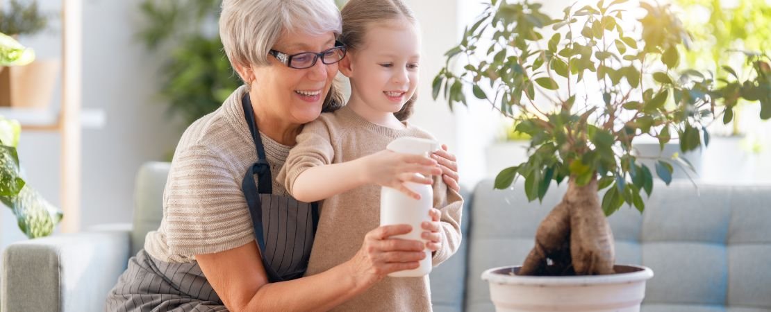 grandmother and granddaughter happily watering a money tree